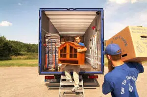 Zwei Umzugsmitarbeiter verpacken Pakete in einen Lieferwagen