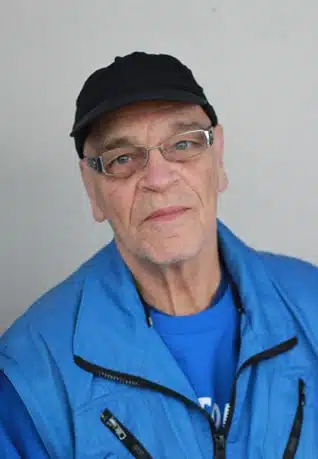 Ein Umzugshelfer mir Blauer Jacke und schwarzem Kappi