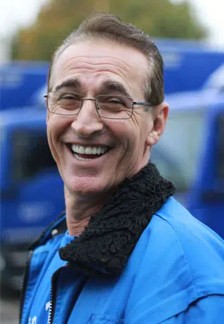 ein Mann mit Brille und blauer Jacke