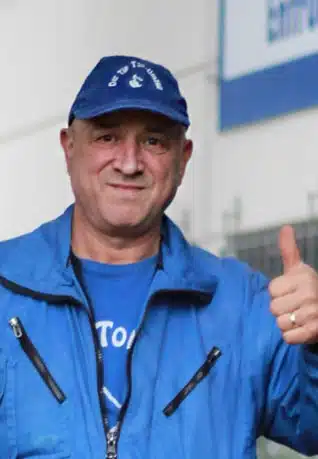 Mann mit blauer Jacke der Daumen hochhält