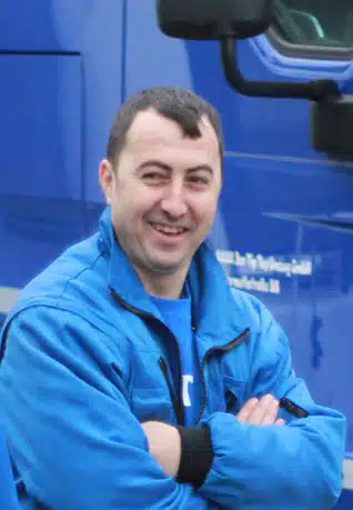 Mann mit verschränkten Armen und blauer Jacke