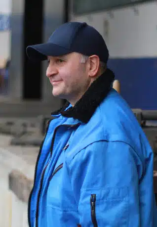 Mann mit blauer Jacke und dunkelblauem Käppi